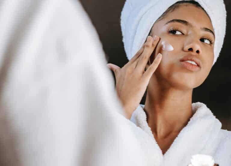 Woman applying cream to face